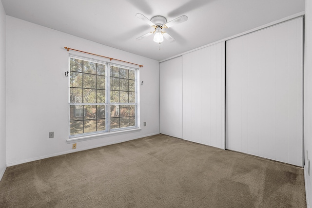 empty room with ceiling fan and carpet floors