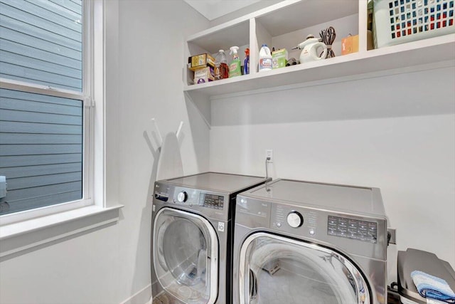 clothes washing area featuring plenty of natural light and washer and clothes dryer