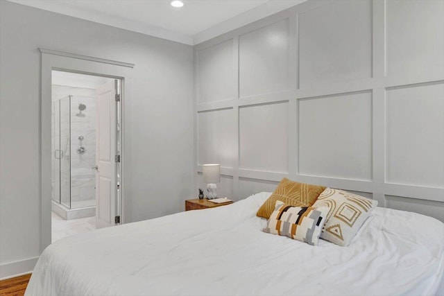 bedroom featuring crown molding, light hardwood / wood-style flooring, and ensuite bathroom