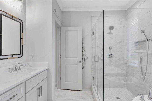 bathroom featuring vanity, a shower with shower door, and ornamental molding