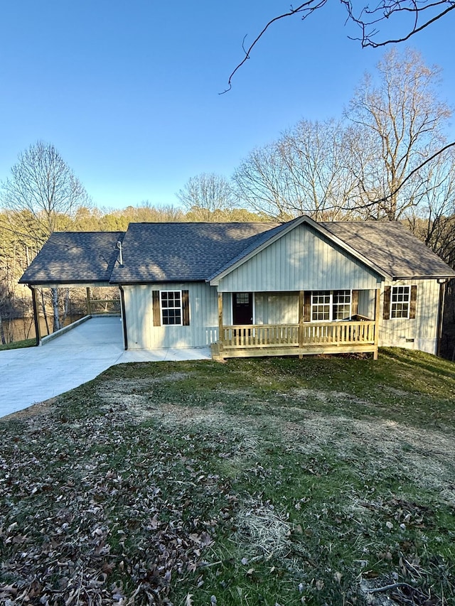 ranch-style house featuring covered porch, a front lawn, and a carport