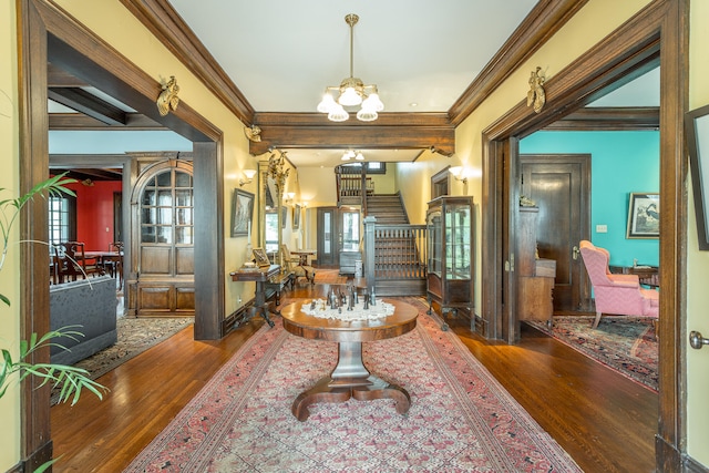 foyer with crown molding, hardwood / wood-style flooring, and a chandelier