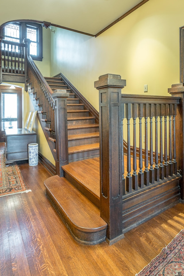 stairs featuring a wealth of natural light, hardwood / wood-style flooring, and ornamental molding