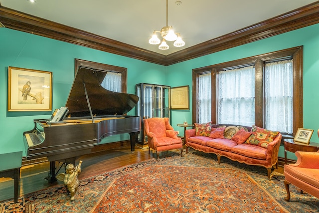 living area featuring ornamental molding, wood-type flooring, and a chandelier