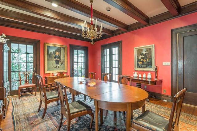 dining space featuring wood-type flooring, a wealth of natural light, beam ceiling, and ornamental molding