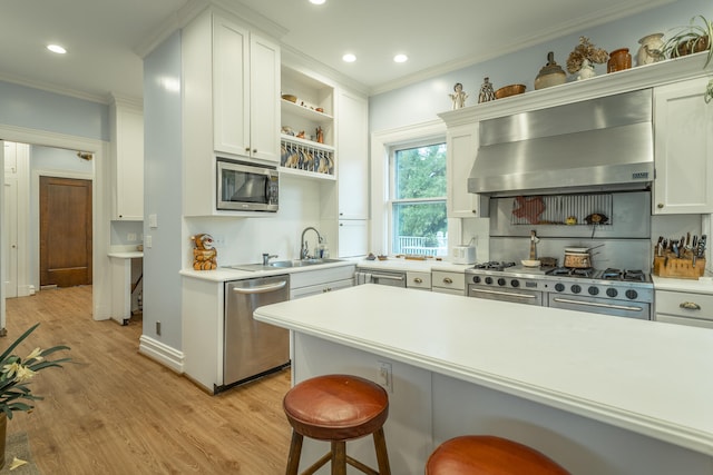 kitchen with white cabinetry, light hardwood / wood-style flooring, stainless steel appliances, and range hood