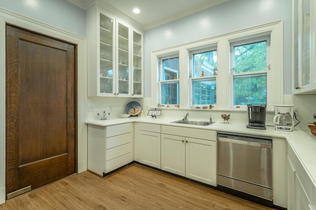 kitchen with stainless steel dishwasher, ornamental molding, sink, light wood-type flooring, and white cabinets