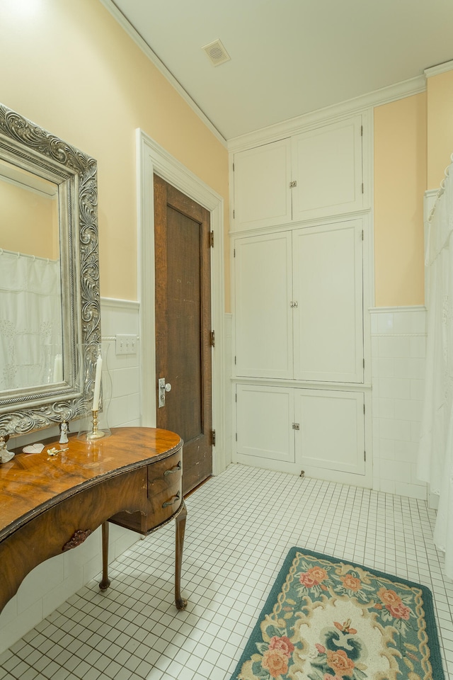 interior space featuring crown molding, tile walls, and tile patterned flooring