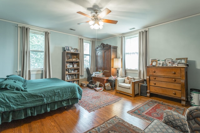 bedroom featuring ceiling fan, crown molding, and wood-type flooring