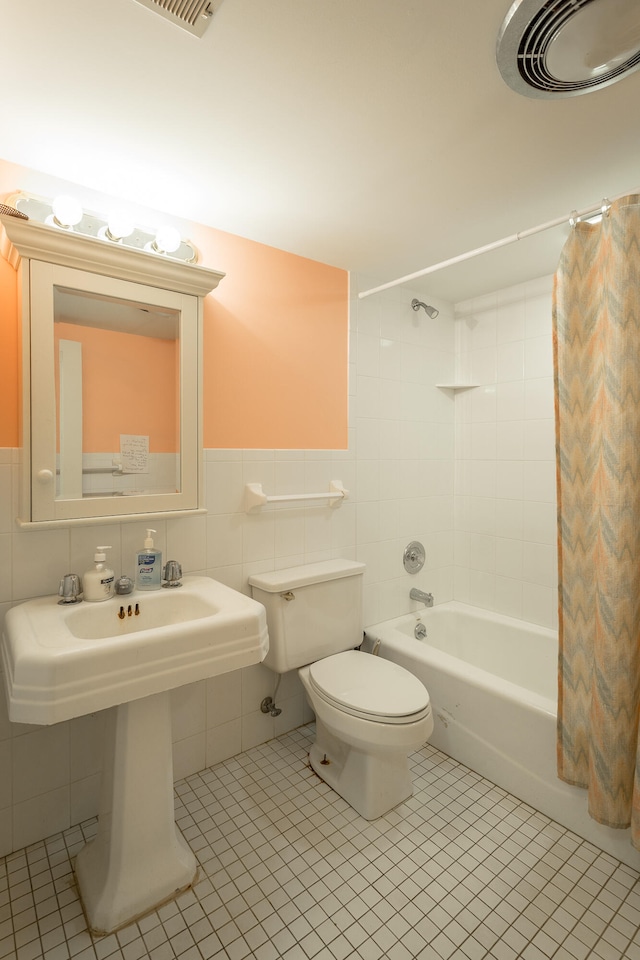 bathroom featuring backsplash, tile patterned flooring, toilet, tile walls, and shower / bath combination with curtain