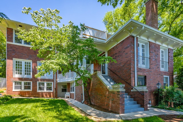 view of front of home featuring a front lawn and a balcony