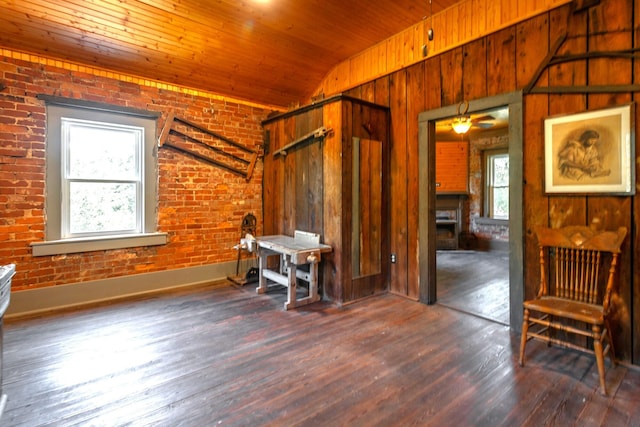 bedroom with brick wall, vaulted ceiling, and dark wood-type flooring