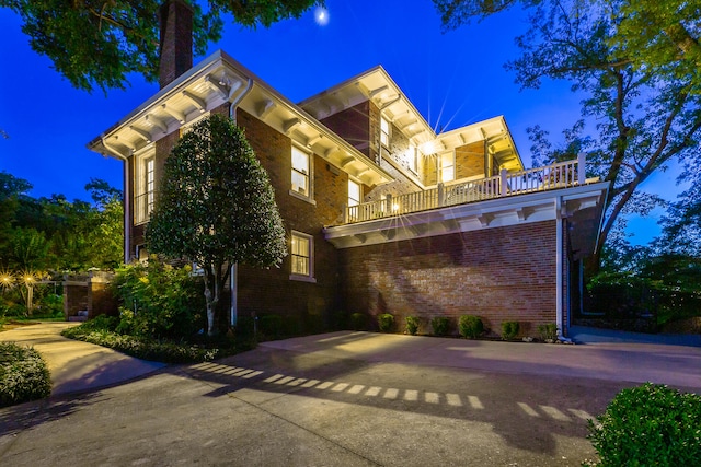 property exterior at twilight with a balcony