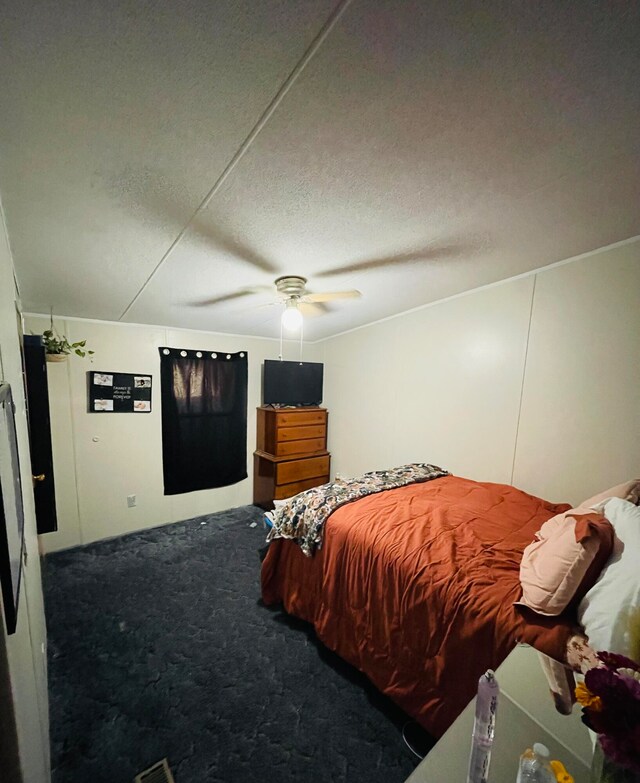 carpeted bedroom featuring a textured ceiling and ceiling fan