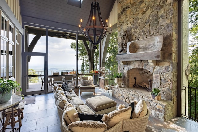 sunroom with an outdoor stone fireplace, an inviting chandelier, wooden ceiling, and lofted ceiling