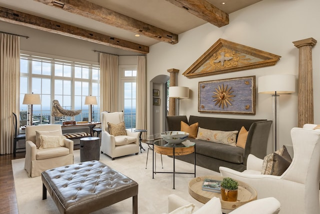 living room featuring decorative columns, hardwood / wood-style flooring, and beam ceiling