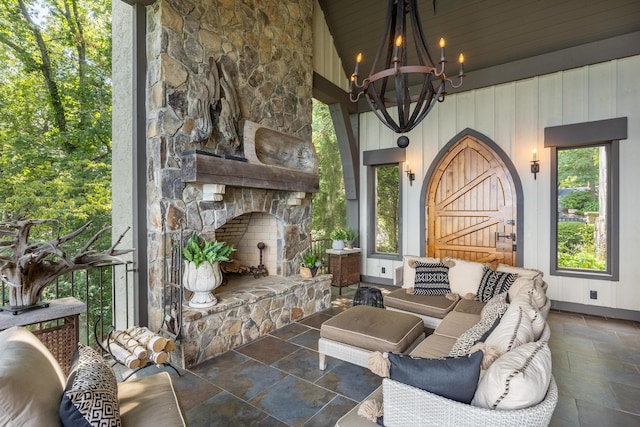 living room with an outdoor stone fireplace, wood ceiling, an inviting chandelier, and vaulted ceiling