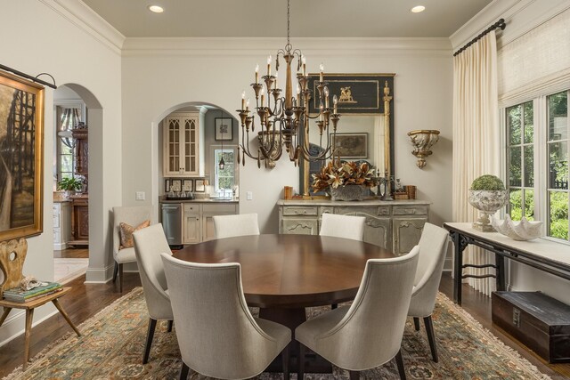 dining space with a wealth of natural light, ornamental molding, dark hardwood / wood-style floors, and a notable chandelier