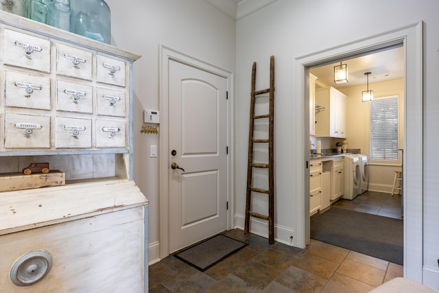 carpeted entryway featuring ornamental molding and separate washer and dryer