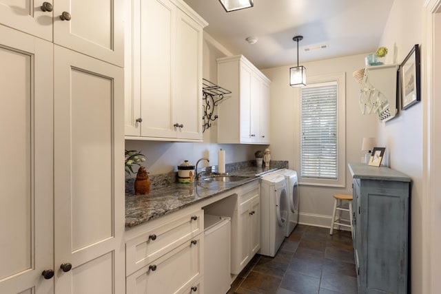 laundry area with cabinets, washing machine and dryer, and sink