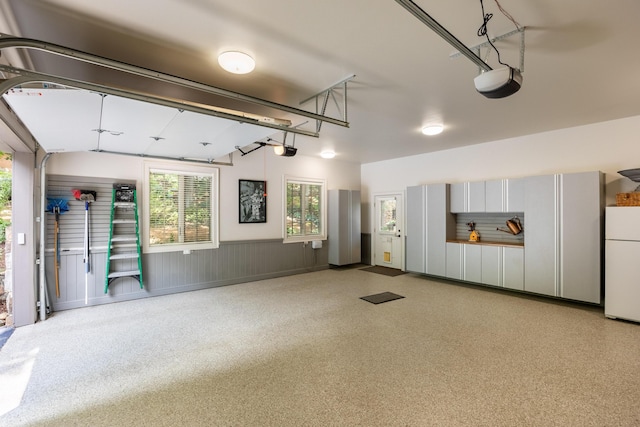 garage featuring a garage door opener and white fridge