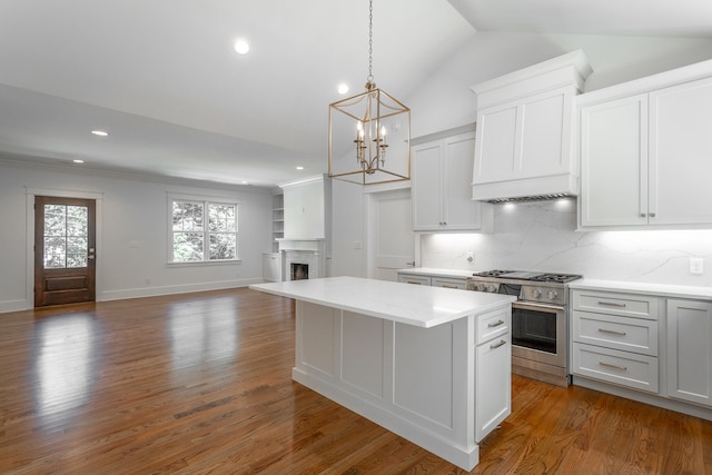 kitchen with dark wood-type flooring, tasteful backsplash, stainless steel range, and a notable chandelier