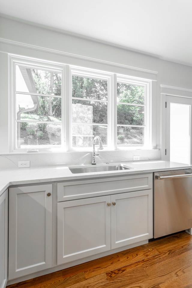 bar with white cabinets, wood-type flooring, sink, and stainless steel dishwasher