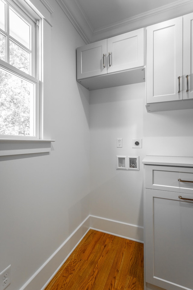 laundry room featuring cabinets, electric dryer hookup, crown molding, hookup for a washing machine, and dark hardwood / wood-style floors