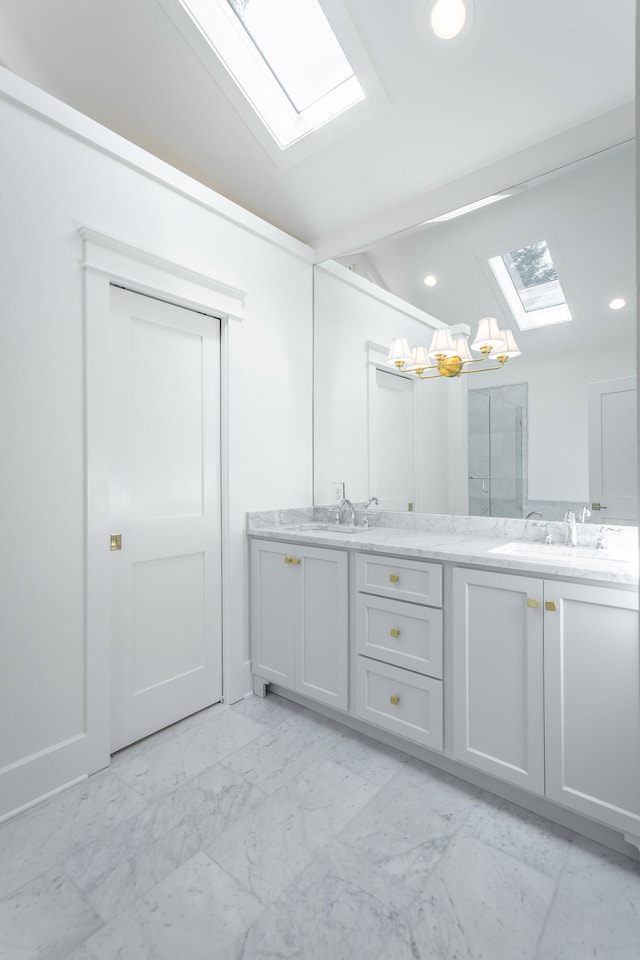 bathroom with vanity and vaulted ceiling with skylight