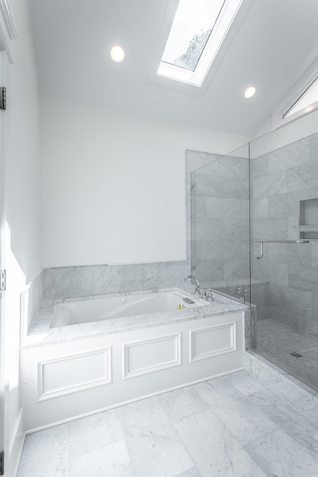 bathroom with vaulted ceiling with skylight and plus walk in shower