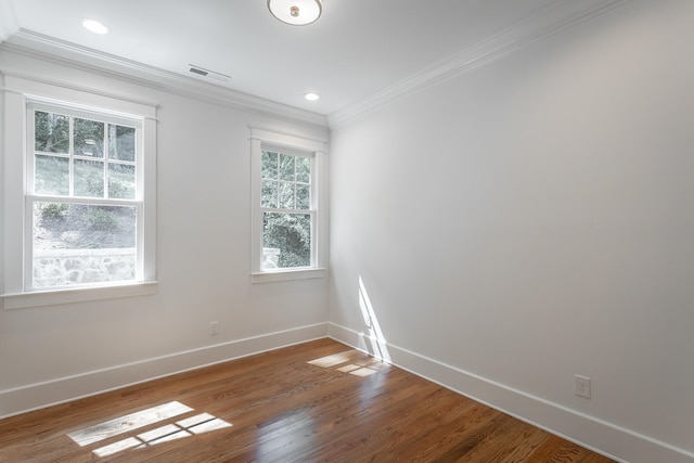 spare room featuring ornamental molding and hardwood / wood-style flooring