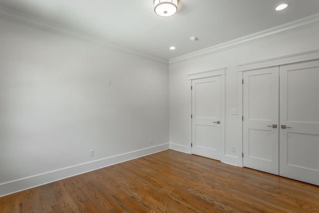 unfurnished bedroom featuring hardwood / wood-style floors, a closet, and crown molding