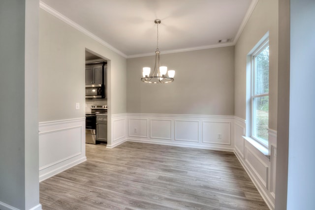 unfurnished dining area featuring crown molding, plenty of natural light, an inviting chandelier, and light hardwood / wood-style flooring