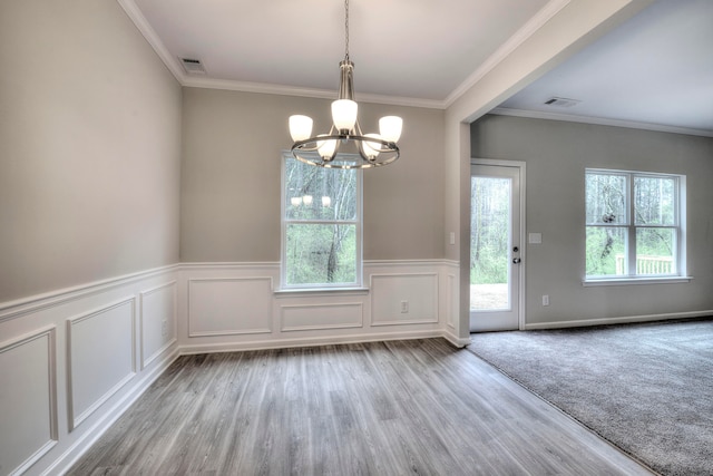 unfurnished dining area featuring crown molding, a notable chandelier, and light hardwood / wood-style floors