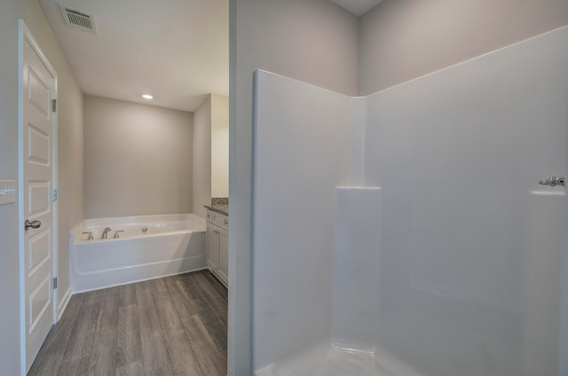 bathroom featuring vanity, wood-type flooring, and shower with separate bathtub