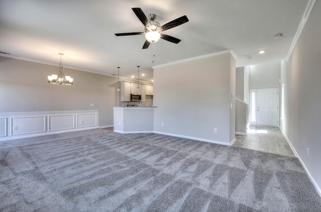 unfurnished living room with ceiling fan with notable chandelier, crown molding, and light carpet