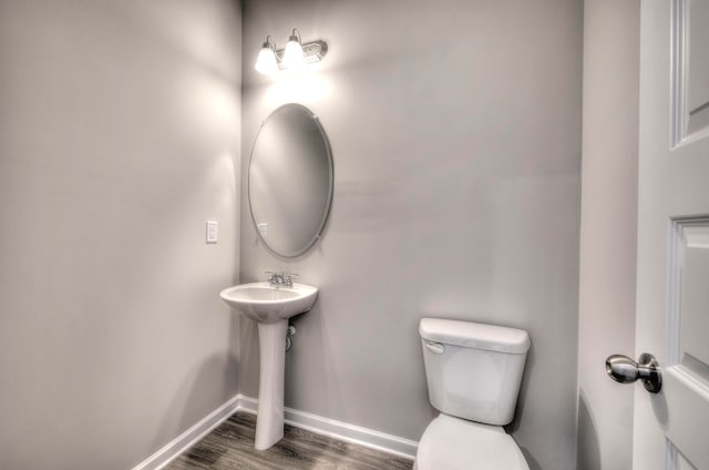 bathroom featuring toilet, hardwood / wood-style flooring, and sink