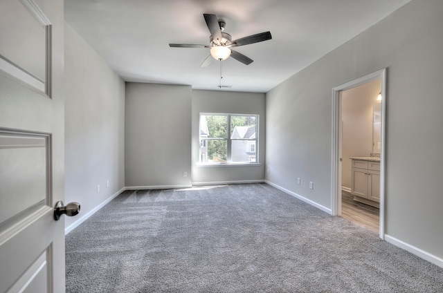 carpeted spare room with ceiling fan