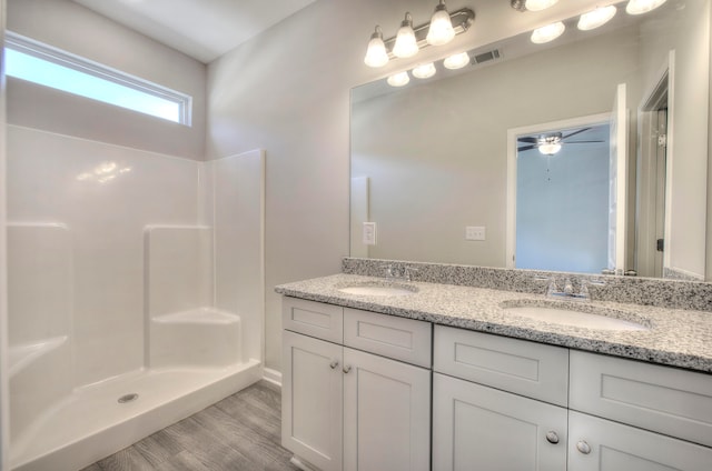 bathroom featuring vanity, ceiling fan, wood-type flooring, and walk in shower