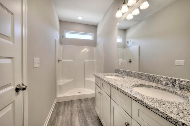 bathroom featuring a shower, vanity, and hardwood / wood-style flooring