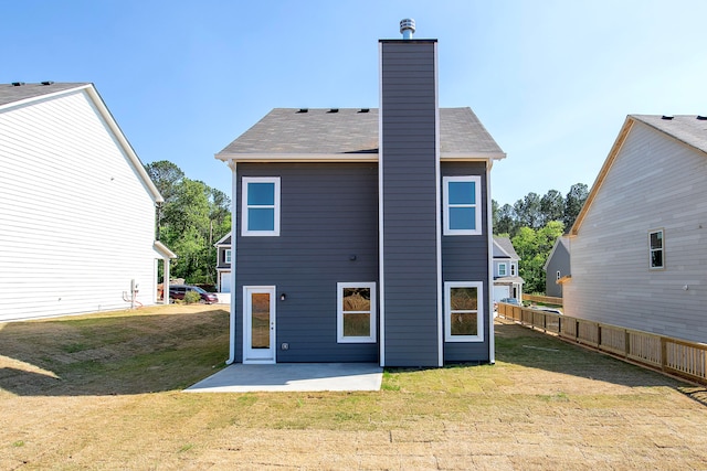 back of property with a lawn and a patio area