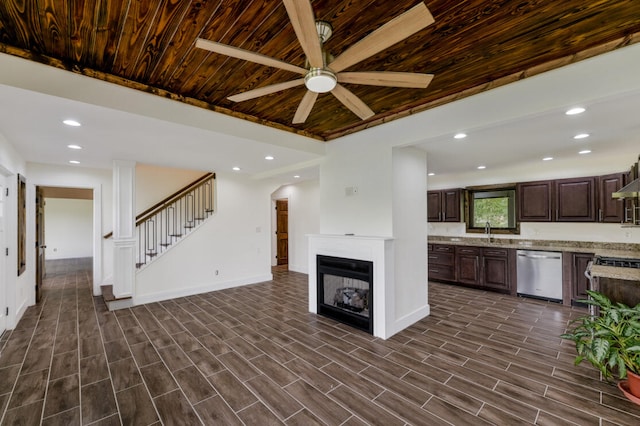 kitchen featuring dark hardwood / wood-style flooring, light stone countertops, ceiling fan, wooden ceiling, and appliances with stainless steel finishes