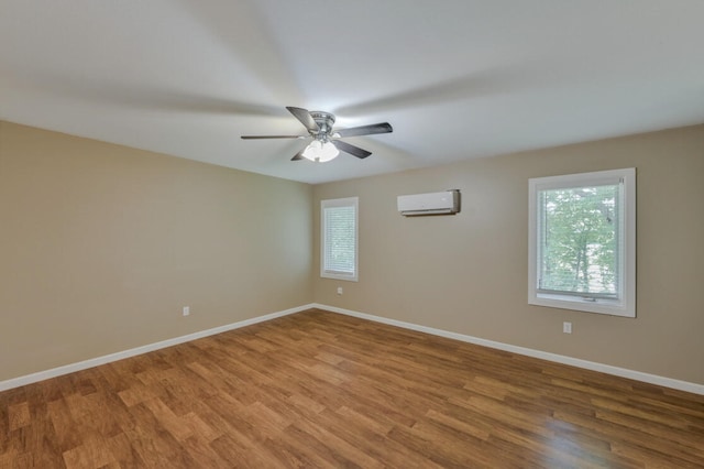 spare room featuring a wall mounted AC, ceiling fan, and hardwood / wood-style flooring