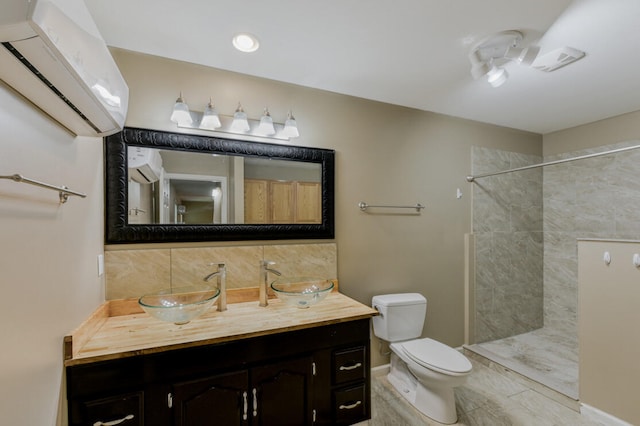 bathroom featuring vanity, tasteful backsplash, tiled shower, a wall mounted air conditioner, and toilet