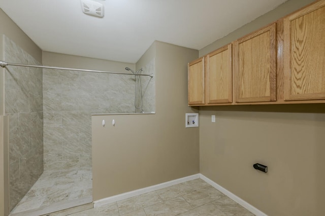 clothes washing area with washer hookup and cabinets