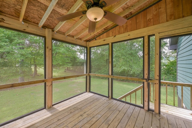 unfurnished sunroom with ceiling fan and vaulted ceiling