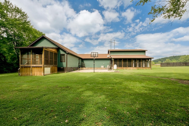 rear view of property featuring a yard and a sunroom