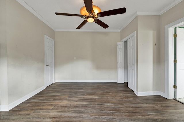 spare room with crown molding and dark wood-type flooring