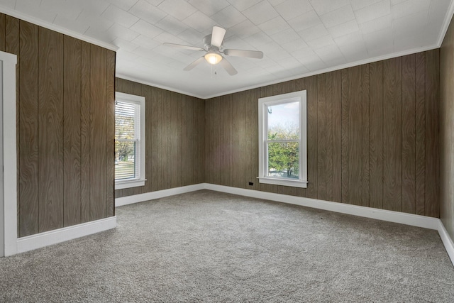 empty room with carpet, ceiling fan, and wood walls