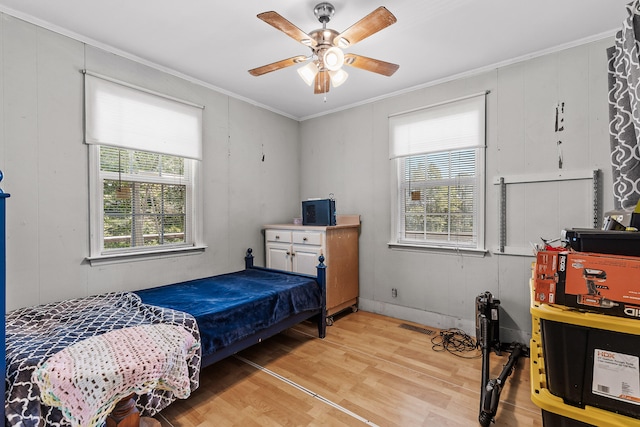 bedroom with light wood-type flooring, multiple windows, crown molding, and ceiling fan